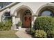 Attractive front entry with coral door, arched entryway, and lush landscaping at 92 Spinnaker Cir, South Daytona, FL 32119