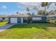 Newly renovated teal home with white garage door and well-manicured lawn at 1214 Margina Ave, Daytona Beach, FL 32114