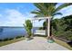 Relaxing patio with waterfront views, pergola, and hanging bench at 1778 John Anderson Dr, Ormond Beach, FL 32176