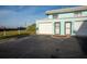 Ground level view of a teal colored building with attached garage and entrance at 2850 Ocean Shore Blvd # 8, Ormond Beach, FL 32176