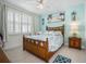 Guest bedroom with light blue accent wall and wicker bed frame at 508 High Tide Ln, Daytona Beach, FL 32124