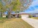 Brick ranch house with a large tree and driveway at 840 Chickadee Dr, Port Orange, FL 32127