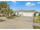 Home with gray paver driveway and palm trees at 21 Tipperary Ln, Ormond Beach, FL 32176