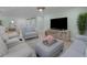 Relaxing living room, featuring light beige sofas and a large TV at 21 Tipperary Ln, Ormond Beach, FL 32176