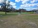 Picturesque golf course view with lush green grass, mature trees, and golf carts, perfect for outdoor recreation at 3142 Silvermines Ave, Ormond Beach, FL 32174