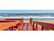 Red wooden walkway leading to a sandy beach at 3370 Ocean Shore Blvd # 3060, Ormond Beach, FL 32176