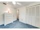 Cozy bedroom with blue carpeting, white dresser, and closet with sliding doors at 812 Whiporwill Dr, Port Orange, FL 32127