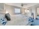 Bright bedroom features a ceiling fan, a large window, and a matching white dresser and bed frame at 812 Whiporwill Dr, Port Orange, FL 32127