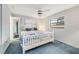 Bright bedroom features a ceiling fan, a large window, and a matching white dresser and bed frame at 812 Whiporwill Dr, Port Orange, FL 32127