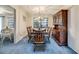 Cozy dining room with wooden table and chairs, a large wooden hutch, and blue carpet at 812 Whiporwill Dr, Port Orange, FL 32127