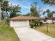 Charming single-story home with attached garage, lush landscaping and a concrete driveway at 812 Whiporwill Dr, Port Orange, FL 32127