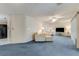 Spacious living room with plush blue carpeting, white furniture and lamps with tile flooring in the adjacent kitchen at 812 Whiporwill Dr, Port Orange, FL 32127