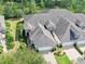 Aerial view of the property highlighting the well-manicured lawn, mature trees, and the roof at 820 Aldenham Ln, Ormond Beach, FL 32174