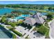 Aerial view showcases clubhouse, pool with palm trees, and water features beside scenic lake at 820 Aldenham Ln, Ormond Beach, FL 32174
