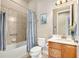 Cozy bathroom with tiled shower and tub, complemented by a wooden vanity and neutral finishes at 820 Aldenham Ln, Ormond Beach, FL 32174