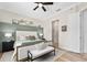 Cozy bedroom featuring a decorative wall, ceiling fan, and a comfortable bed with a cushioned bench at 820 Aldenham Ln, Ormond Beach, FL 32174