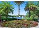 Prestwick Park sign with vibrant flowers and swaying palm trees overlooking tranquil lake and fountain at 820 Aldenham Ln, Ormond Beach, FL 32174