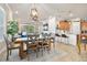 Open-concept dining room with wood table, chairs, and modern lighting flowing into the kitchen at 820 Aldenham Ln, Ormond Beach, FL 32174