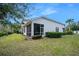 Rear exterior view of the house highlighting the screened-in porch and well-maintained landscaping at 820 Aldenham Ln, Ormond Beach, FL 32174