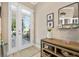 Cozy foyer with double french doors, console table with decor, and a decorative mirror at 820 Aldenham Ln, Ormond Beach, FL 32174