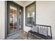 Inviting front porch with a bench, cushions, a new door, and brick flooring at 820 Aldenham Ln, Ormond Beach, FL 32174