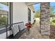 Comfortable front porch with a bench, cushions, nice landscaping, and brick flooring at 820 Aldenham Ln, Ormond Beach, FL 32174