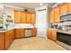 Bright kitchen with stainless steel appliances, tile backsplash, and wooden cabinetry providing ample storage space at 820 Aldenham Ln, Ormond Beach, FL 32174