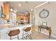 Kitchen island with pendant lights and bar stool seating and decor on a hall table with a clock at 820 Aldenham Ln, Ormond Beach, FL 32174