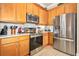 Kitchen with stainless steel appliances, granite countertops, tile backsplash, and wood cabinets at 820 Aldenham Ln, Ormond Beach, FL 32174