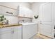 Well-lit laundry room features ample white cabinetry above the washer and dryer for storage at 820 Aldenham Ln, Ormond Beach, FL 32174