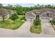 Two-story house with gray roof and brick paver driveway, surrounded by lush landscaping at 830 Aldenham Ln, Ormond Beach, FL 32174