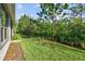 Landscaped backyard with lush green lawn and trees at 830 Aldenham Ln, Ormond Beach, FL 32174