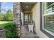 Inviting front porch with stone column, bench, and spacious entryway at 830 Aldenham Ln, Ormond Beach, FL 32174