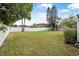 Large grassy backyard with a white vinyl fence at 135 Lagoon Ct, New Smyrna Beach, FL 32169