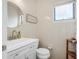 Small bathroom with white vanity, toilet, and tiled walls at 135 Lagoon Ct, New Smyrna Beach, FL 32169