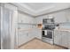 Modern kitchen with stainless steel appliances and gray cabinets at 135 Lagoon Ct, New Smyrna Beach, FL 32169