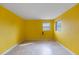 Bedroom with a sunny yellow color, tile flooring, and natural light from two windows at 188 Benjamin Dr, Ormond Beach, FL 32176