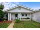 Inviting front porch with decorative plants, and a well-kept lawn create a welcoming entrance to this brick home at 188 Benjamin Dr, Ormond Beach, FL 32176