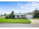 Charming single-story white home featuring a well-maintained lawn, a driveway, and a one-car garage at 188 Benjamin Dr, Ormond Beach, FL 32176