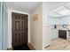 Inviting entryway featuring a brown door adjacent to a kitchen with light blue cabinets and modern appliances at 2100 Ocean Shore Blvd # 1150, Ormond Beach, FL 32176