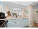 Modern kitchen with light blue cabinetry, a view into the living area, and a cozy breakfast bar at 2100 Ocean Shore Blvd # 1150, Ormond Beach, FL 32176