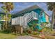 Bright teal building exterior with white railings and stairs. Lush landscaping surrounds the property at 2596 Tulane Ave # 4, Daytona Beach, FL 32118