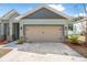 A large two-car garage, landscaped garden beds, and exterior lights complement this home's facade at 46 Chrysanthemum Dr, Ormond Beach, FL 32174