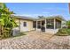 Backyard patio area and screened-in porch, surrounded by lush tropical foliage at 6680 Se 174Th Ln, Summerfield, FL 34491