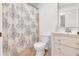 Bathroom with tiled floors, shower with patterned curtain, and updated vanity at 6680 Se 174Th Ln, Summerfield, FL 34491