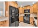 Functional kitchen with stainless steel appliances, wooden cabinetry, and tile flooring at 6680 Se 174Th Ln, Summerfield, FL 34491