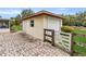 Backyard outbuilding featuring a roll-up door, brick flooring, and a fenced border at 6680 Se 174Th Ln, Summerfield, FL 34491