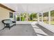 Relaxing sunroom with wicker furniture and panoramic views of the spacious backyard at 6680 Se 174Th Ln, Summerfield, FL 34491