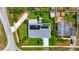 An aerial shot highlights a well-maintained property with solar panels, lush landscaping, and a backyard jacuzzi at 100 Lynnhurst Dr, Ormond Beach, FL 32176
