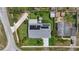 An aerial view showcasing a home with solar panels, landscaping, a backyard jacuzzi, and convenient street access at 100 Lynnhurst Dr, Ormond Beach, FL 32176